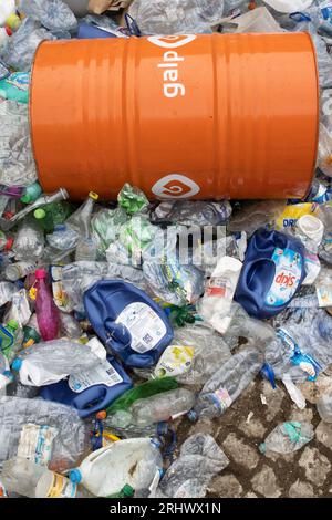 16 october 2022 Almada, Portugal: GALP orange barrel laying on top of plastic garbage. Vertical shot Stock Photo