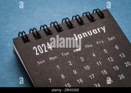 January 2024 Black spiral desktop calendar on red textile Stock Photo ...