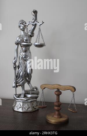 Statue of a woman symbolizing justice and law. wooden scales of justice. Stock Photo