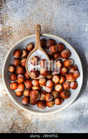 Top view of fresh chestnuts placed in ceramic bowl with a spoon in a concrete background Stock Photo