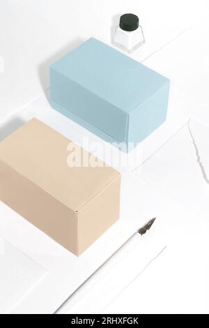 High angle of composition with tea boxes, a writing pen and ink against white background Stock Photo