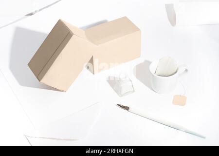 High angle of composition with tea boxes, a writing pen and ink against white background Stock Photo