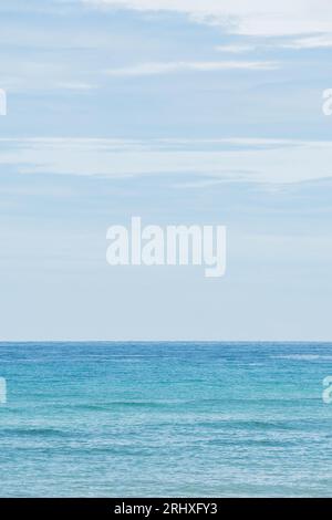 Scenic view of blue wavy ocean water with horizon line under cloudy blue sky in nature at daylight Stock Photo