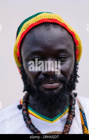Portrait of African American man in colorful hat standing and looking at camera against white background Stock Photo