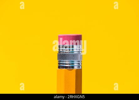 Closeup of yellow pencil with red rubber on blue background representing the concept of education Stock Photo