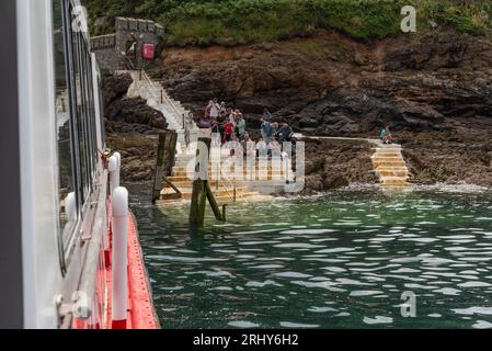 Herm, Channel Islands. 11 June 2023.  The Rosaire Steps, Herm at low tide  seen from an approaching passenger ferry inbound. Passengers wait onshore. Stock Photo