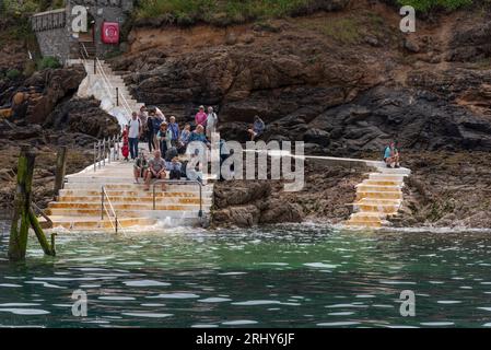 Herm, Channel Islands. 11 June 2023.  The Rosaire Steps, Herm at low tide  seen from an approaching passenger ferry inbound. Passengers wait onshore. Stock Photo