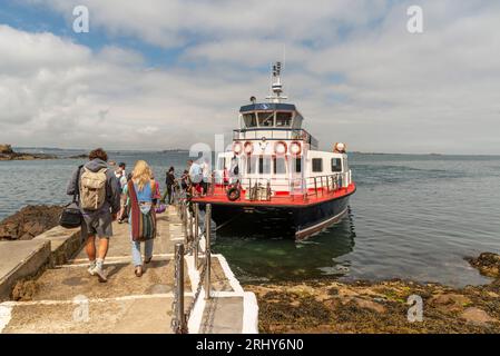 Herm, Channel Islands. 11 June 2023.  Foot passengers arrive from St Peter Port, Guernsey and departing  from the Rosaire Steps, Herm at low tide. Stock Photo