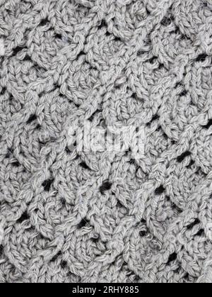 Gray Knitting pattern close-up. Knitting is an easy pattern for beginners. Texture of a knitted sweater. Warm thread pattern in the shape of a fan Stock Photo