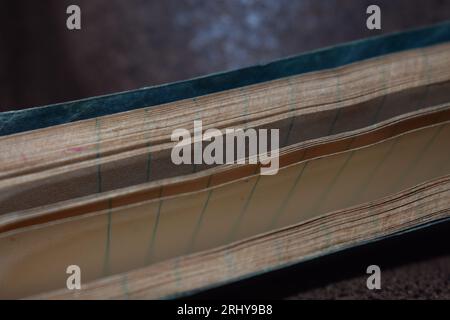 The edge of a small notebook or memo pad from the late 1940's, showing both the edge and parts of the sheets of paper inside. Stock Photo