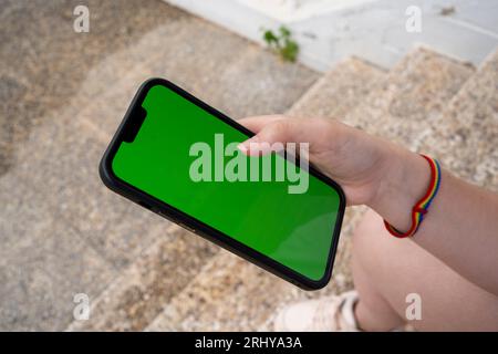 Unrecognizable young woman sitting and browsing smartphone Stock Photo