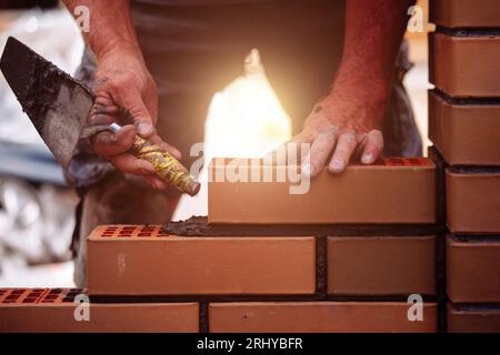 Builder laying bricks on construction site Stock Photo
