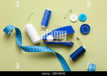 Manual sewing machine with different supplies on green background Stock Photo