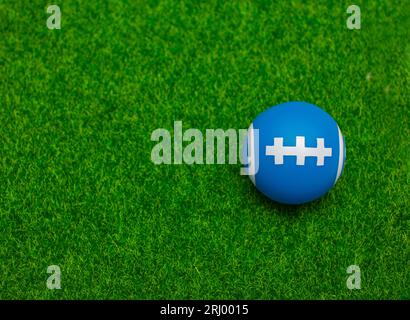 Ball for American football on fresh green field grass, top view. Space for text Stock Photo