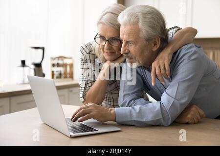 Focused elderly senior couple using online application Stock Photo