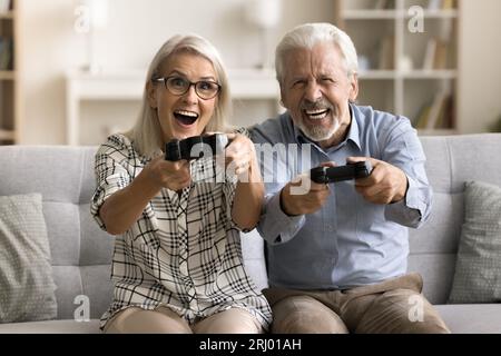 Happy crazy retired couple excited with online video game Stock Photo