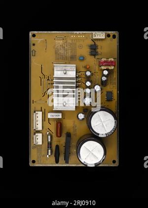 electronic components assembly on a power control inverter circuit motherboard used in electrical equipments isolated in a black background Stock Photo