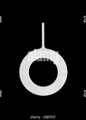 a micro mobile sim card eject pin or key tool isolated in a black background Stock Photo