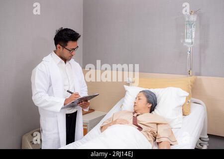 Doctor checkup and diagnostic with patient elderly woman for prescription or planning rehabilitation at hospital, physician talking with patient and w Stock Photo