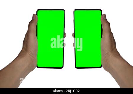 Human hand showing mobile smartphone with green screen in vertical position isolated on white background. Stock Photo