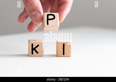 Business concept growth success process. Male hand. Wood blocks and circles with word 'KPI' and arrows stacking as step stair on white background Stock Photo
