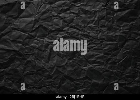 crumpled paper texture, black cardboard sheet, gloomy background Stock Photo