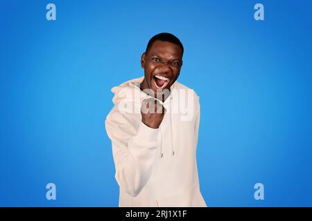Laughing confident glad millennial african american guy in sweatshirt has fun with open mouth Stock Photo