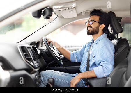 Excited indian guy going to office in morning, driving car Stock Photo