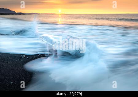 Ice, waves, Sun and beautiful Iceland during sunrise Stock Photo