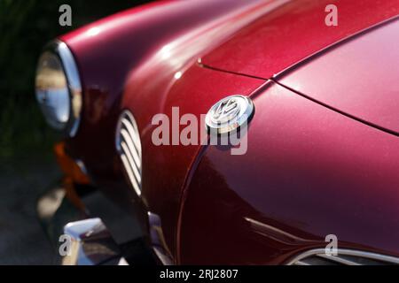 Langeac, France - May 27, 2023: Vintage VW Volkswagen Karmann Ghia Classic Cars in red color. Front view of the hood, bumper and logo Stock Photo
