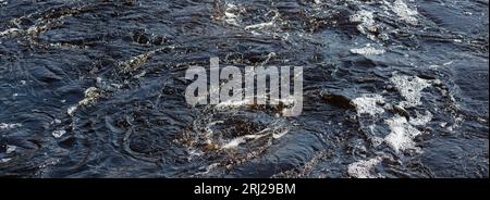 Blue river water with bubbling foam and whirlpools. Banner. Texture. Background. Horizontal Stock Photo