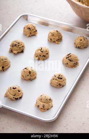 Chocolate chip cookie dough scooped on a cookie sheet ready to be baked Stock Photo