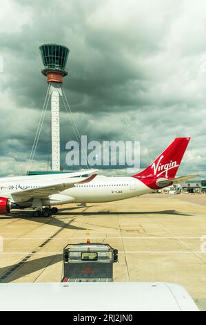 Virgin aircraft with Heathrow air traffic control tower at London Heathrow airport Stock Photo