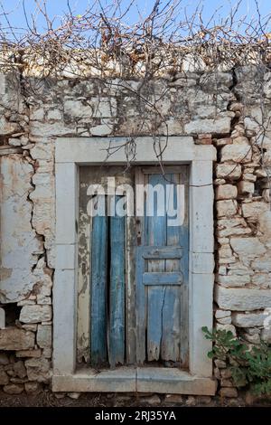 Old wooden door of an abandoned traditional house at the picturesque village of Fourni, in the mountainous region of Merambello in Lasithi, Crete Stock Photo
