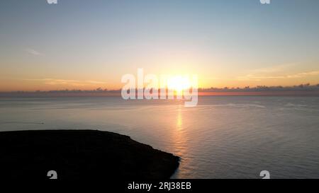 Aerial shot of beautiful sunrise over Cala Petita island in Mallorca, Spain Stock Photo