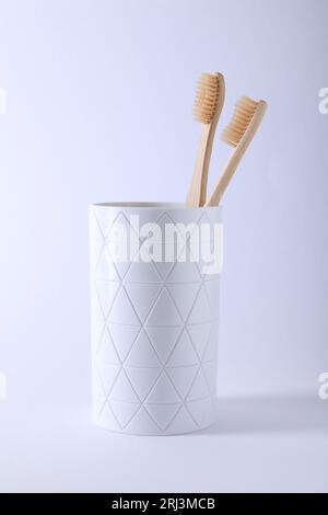 Bamboo toothbrushes in holder on light blue background, closeup Stock ...