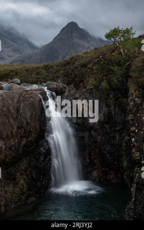 A beautiful waterfall with long exposure cascading in a forest in the daylight Stock Photo