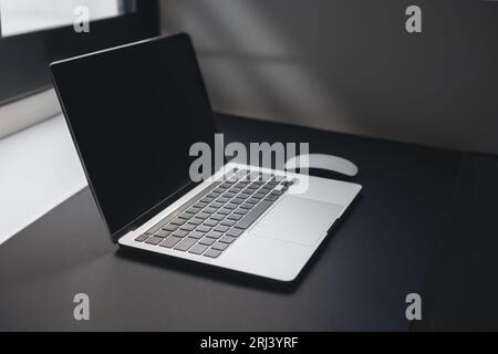 a laptop on table near window Stock Photo