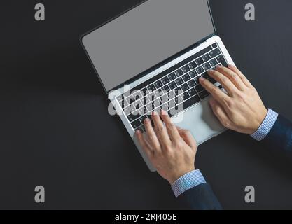 Business man hand typing on laptop computer on office table, close up Stock Photo