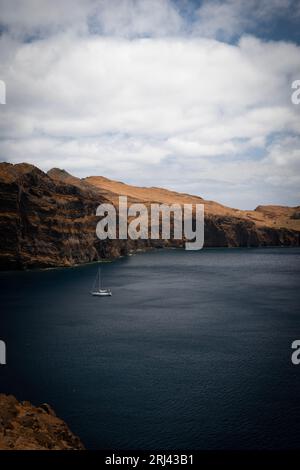 This stunning image captures a boat sailing across a serene lake in the Ponta de Sao Lourenco, a region located in the eastern part of Madeira Stock Photo