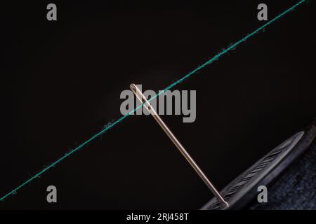 A closeup of a Needle and the thread on the black background Stock Photo