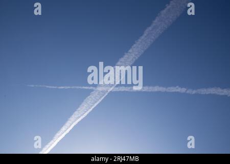 Chemical trails in the sky making an X Stock Photo