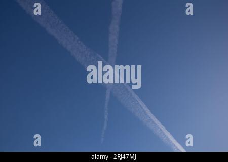 Chemical trails in the sky making an X Stock Photo