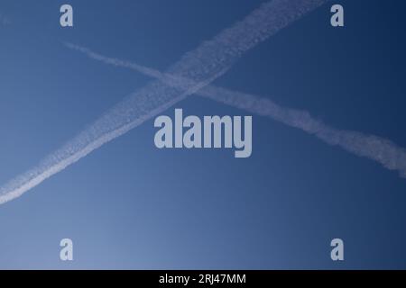 Chemical trails in the sky making an X Stock Photo