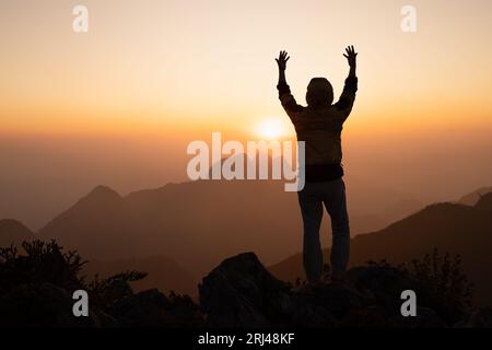 silhouette of a man Praying hands with faith in religion and belief in God On the morning sunrise background.  Prayer position. Stock Photo