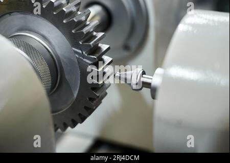 Grey cogwheel and oil nozzle in manufacturing workshop Stock Photo