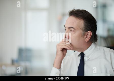 Portrait of pensive middle-aged businessman thinking on ideas for new business plan Stock Photo