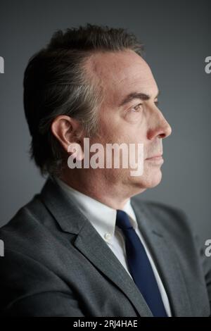 Profile portrait of serious mature businessman in grey suit Stock Photo