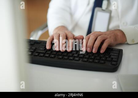 Hands of general practitioner typing on keyboard Stock Photo