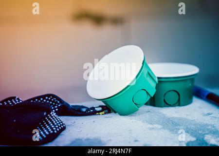 Green mounting box for socket at a construction site close-up. Mounting round socket in the wall Stock Photo